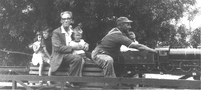 Black and white picture of model steam engine with driver and four passengers at SASMEE park